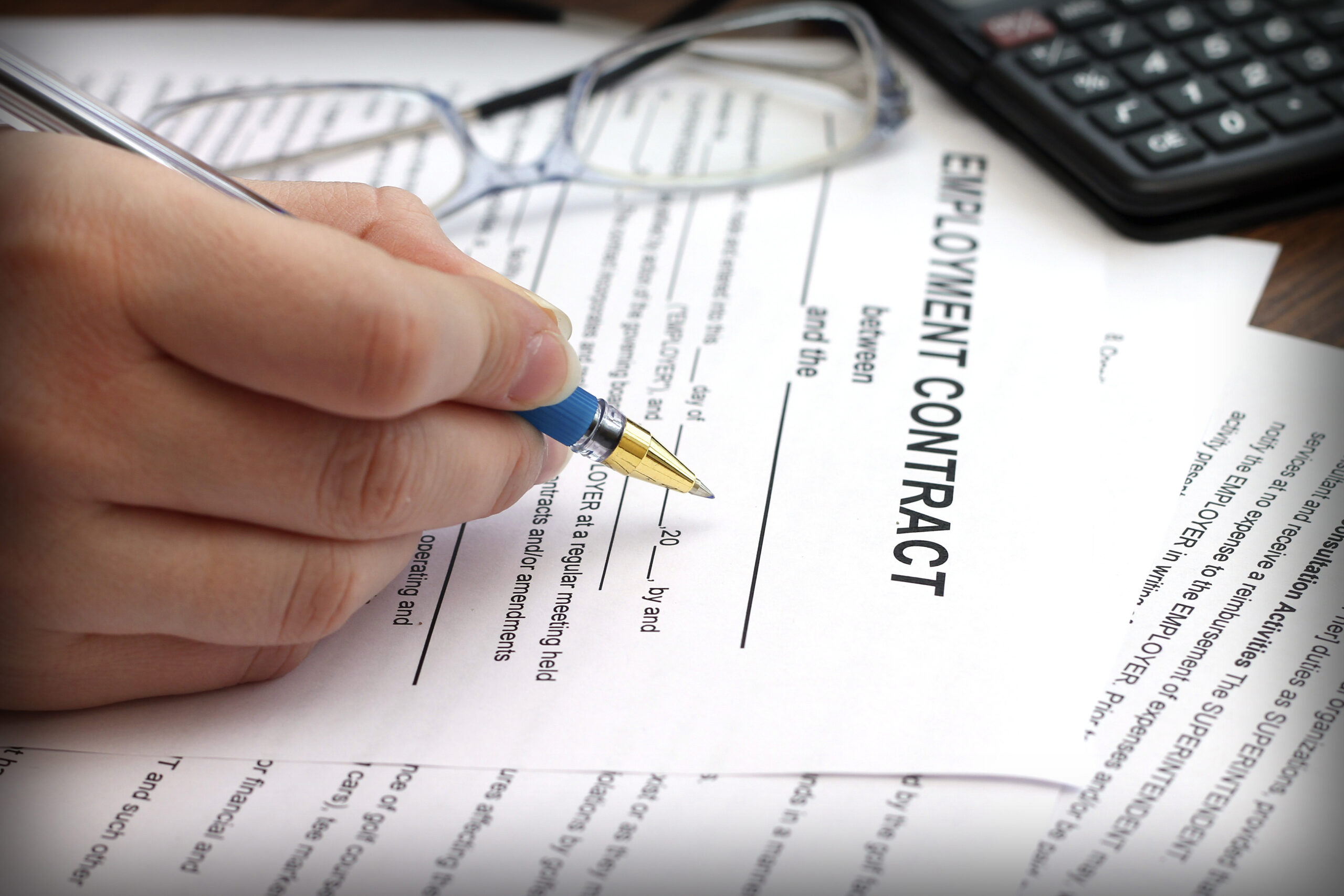 woman’s hands signing an employment contract, close-up