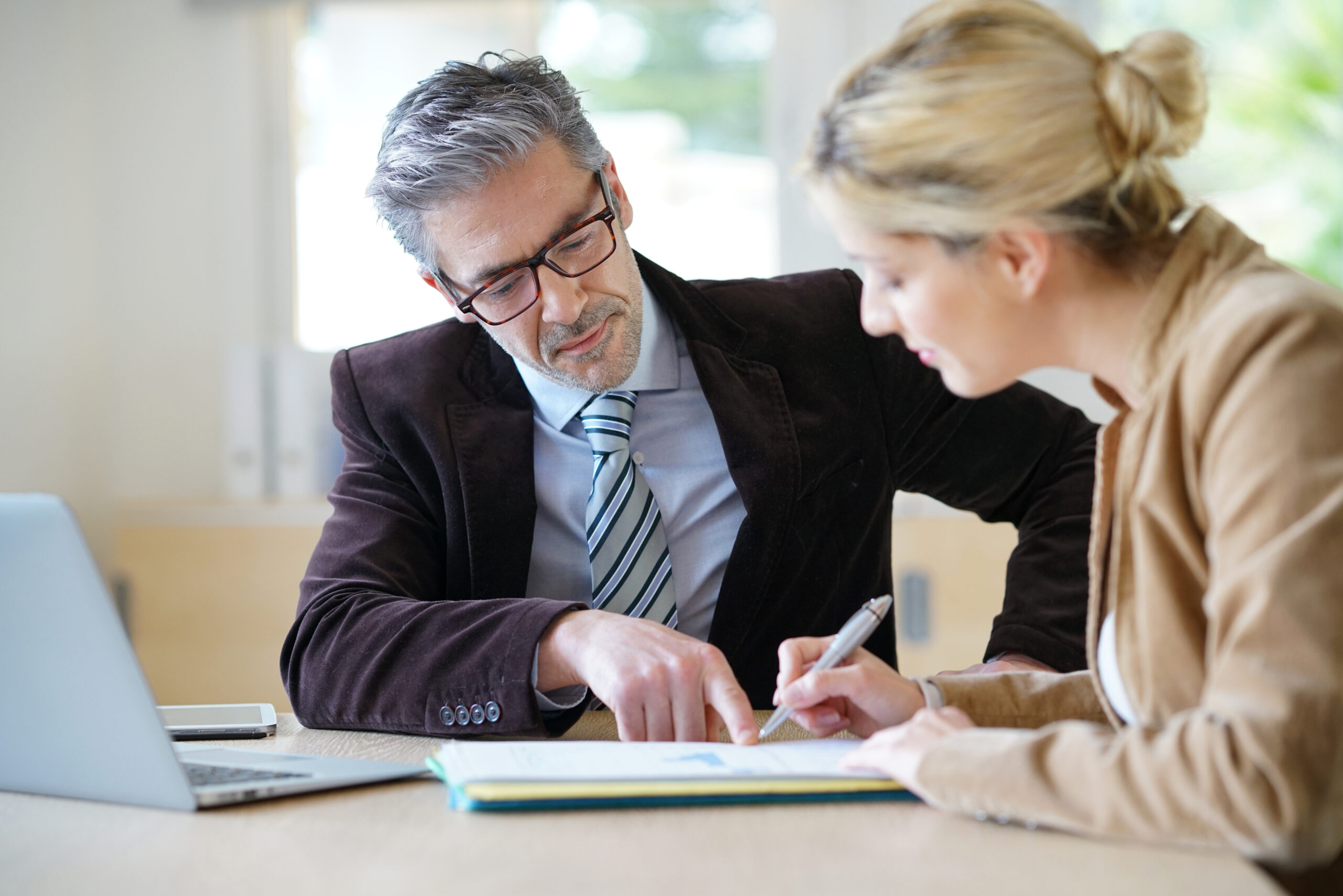 Man and women looking and signing document