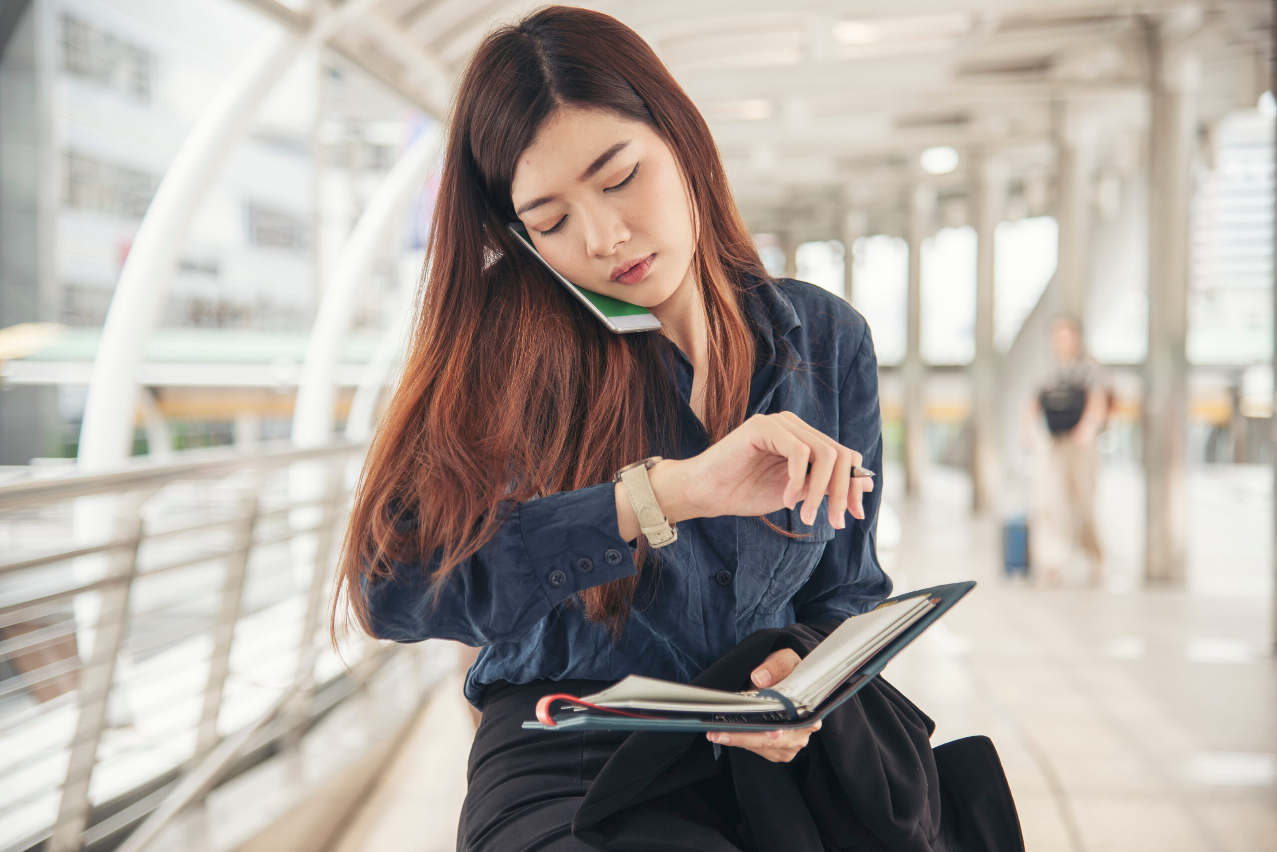 Time out concept. Urgent work, business woman seeing wrist watch and using mobile phone before meeting. Smart woman check the schedule before going to the office.