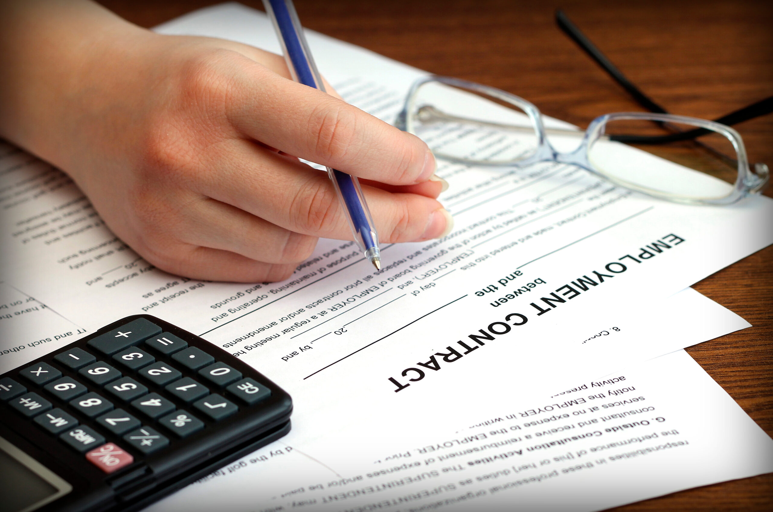 woman’s hands signing an employment contract, close-up