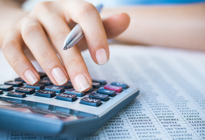 Women typing on calculator with pen