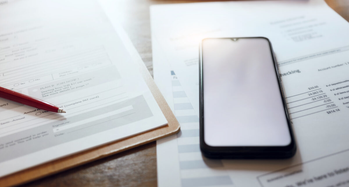 Close-up view, pen with document and mobile phone on desk office prepared for signing loan documents and business contract to start new business