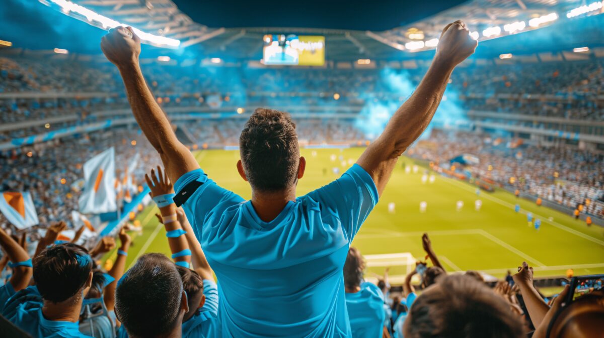 group of Sky Blue football team fans cheer and celebrating a winning tournament or winning league in stadium. the fans wearing sky blue shirt.