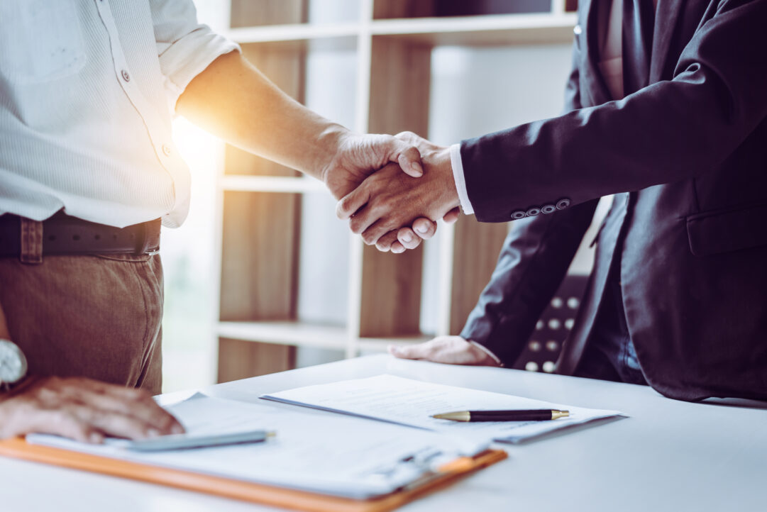 two business men shaking hands after discussing contract