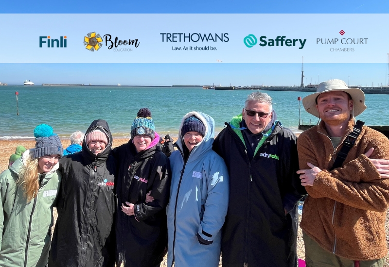 photo at the beach with the team who are swimming the channel with the logos of the sponsors
