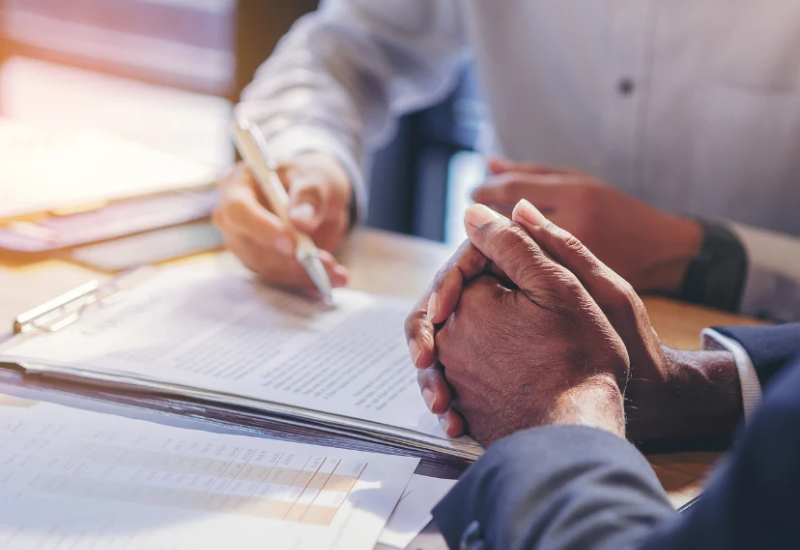 2 men looking over contract in meeting