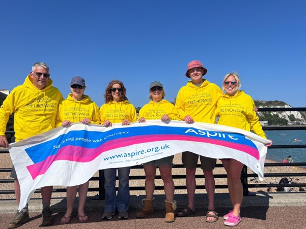 Picture of the swim team holding the aspire flag.